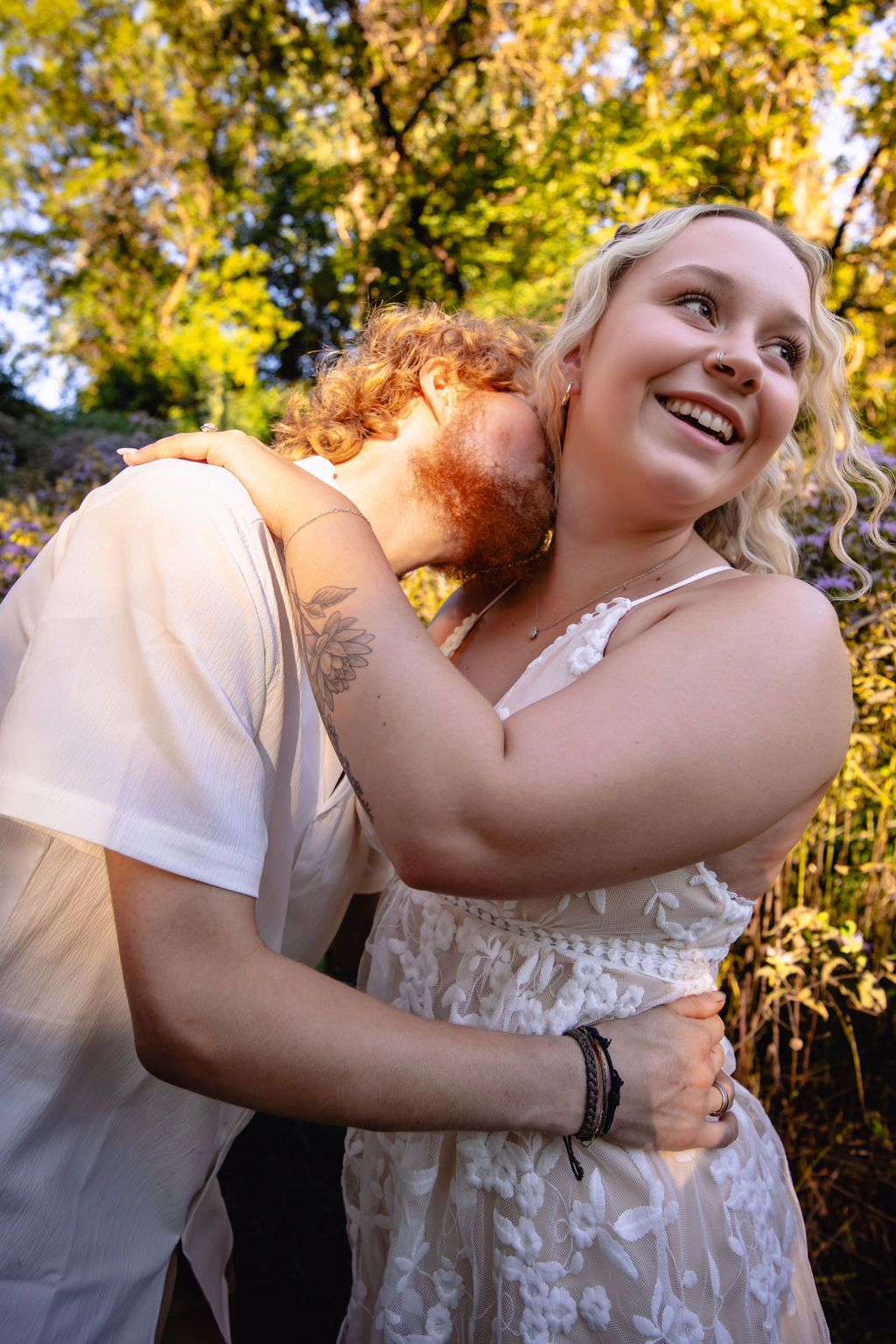 Intimate outdoor portrait in sunlit autumn setting with white outfits.