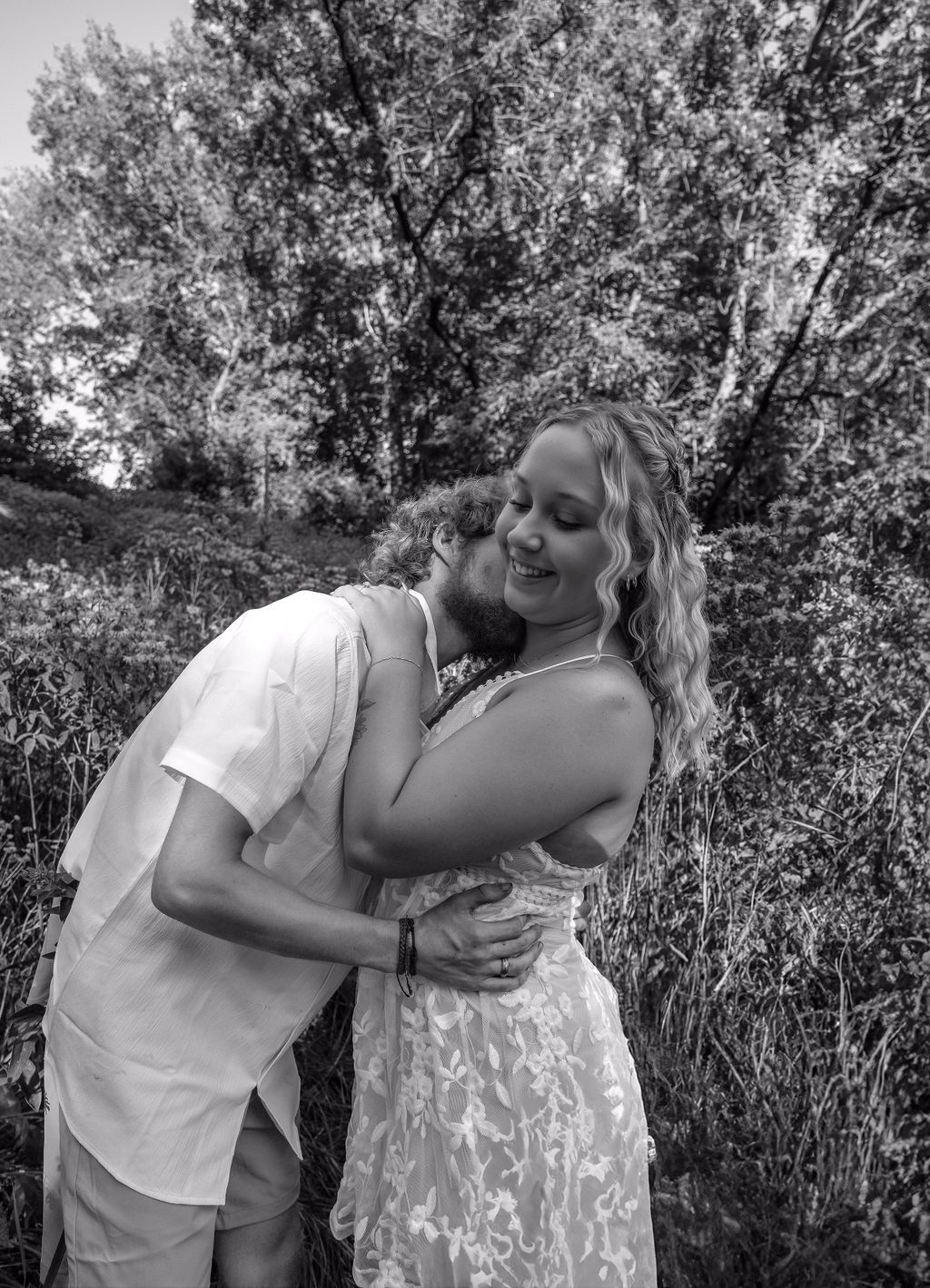 Black and white romantic portrait captured in natural woodland setting.