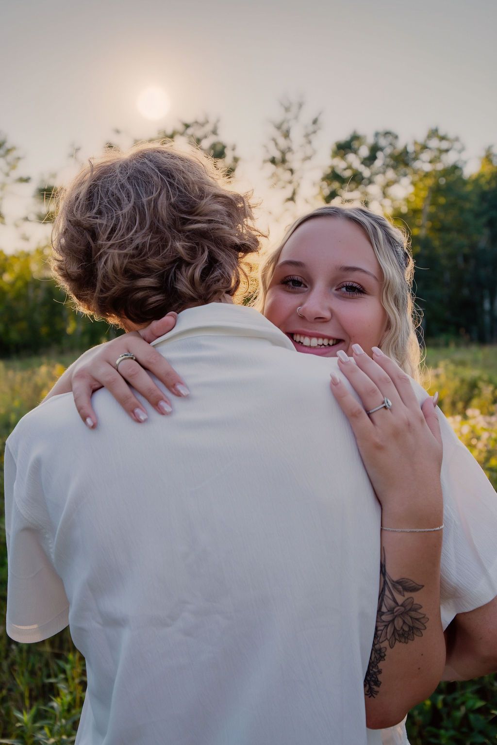 Candid romantic embrace captured in outdoor summer setting.
