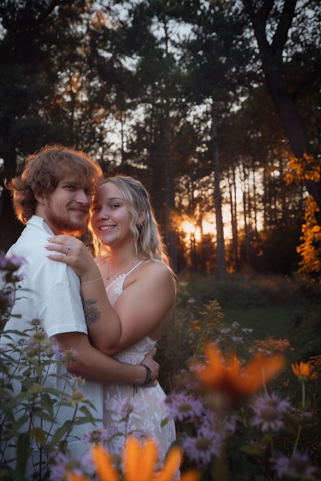 Romantic sunset moment between couple with purple wildflowers in foreground.
