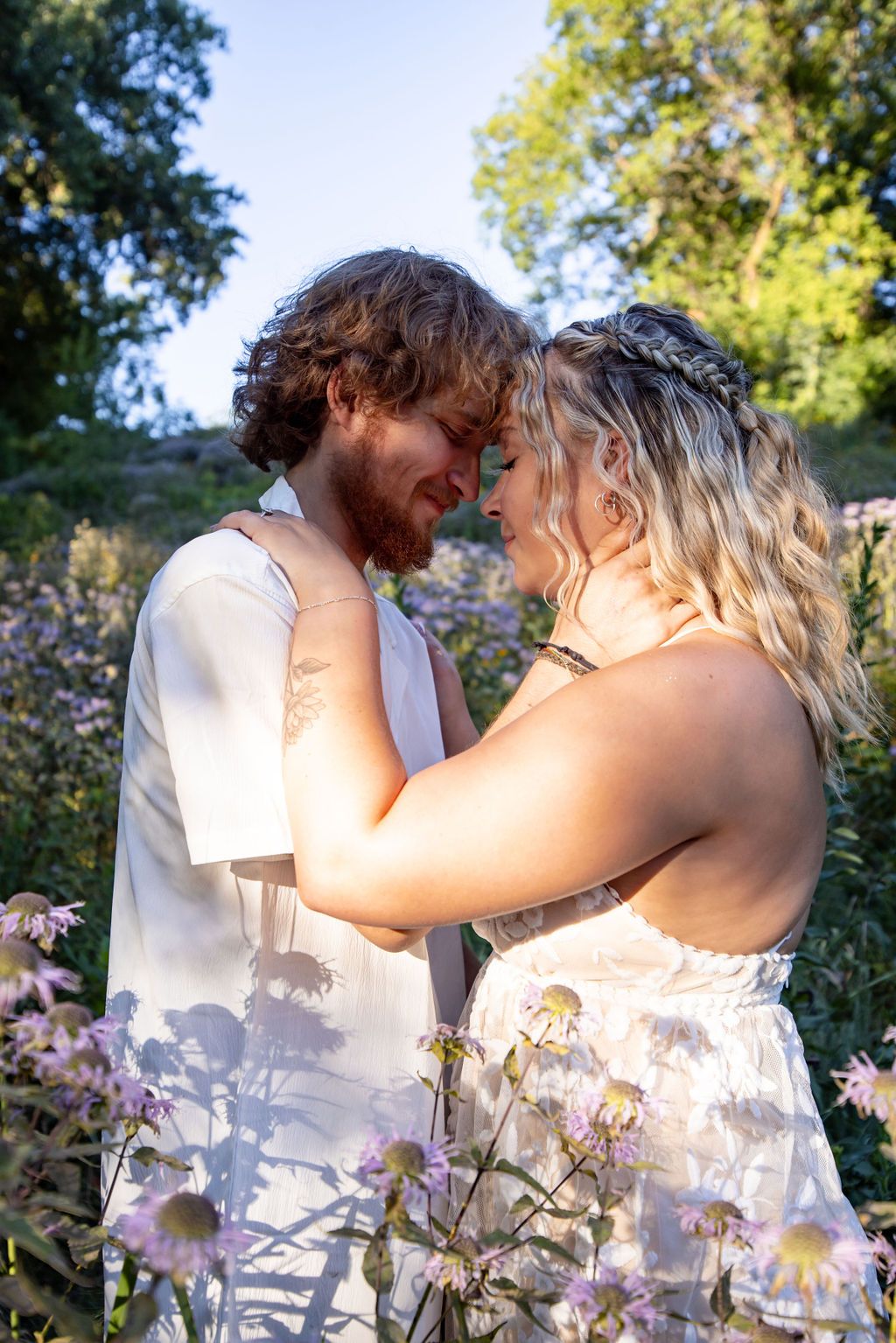 A couple shares a tender moment among blooming wildflowers in summer.