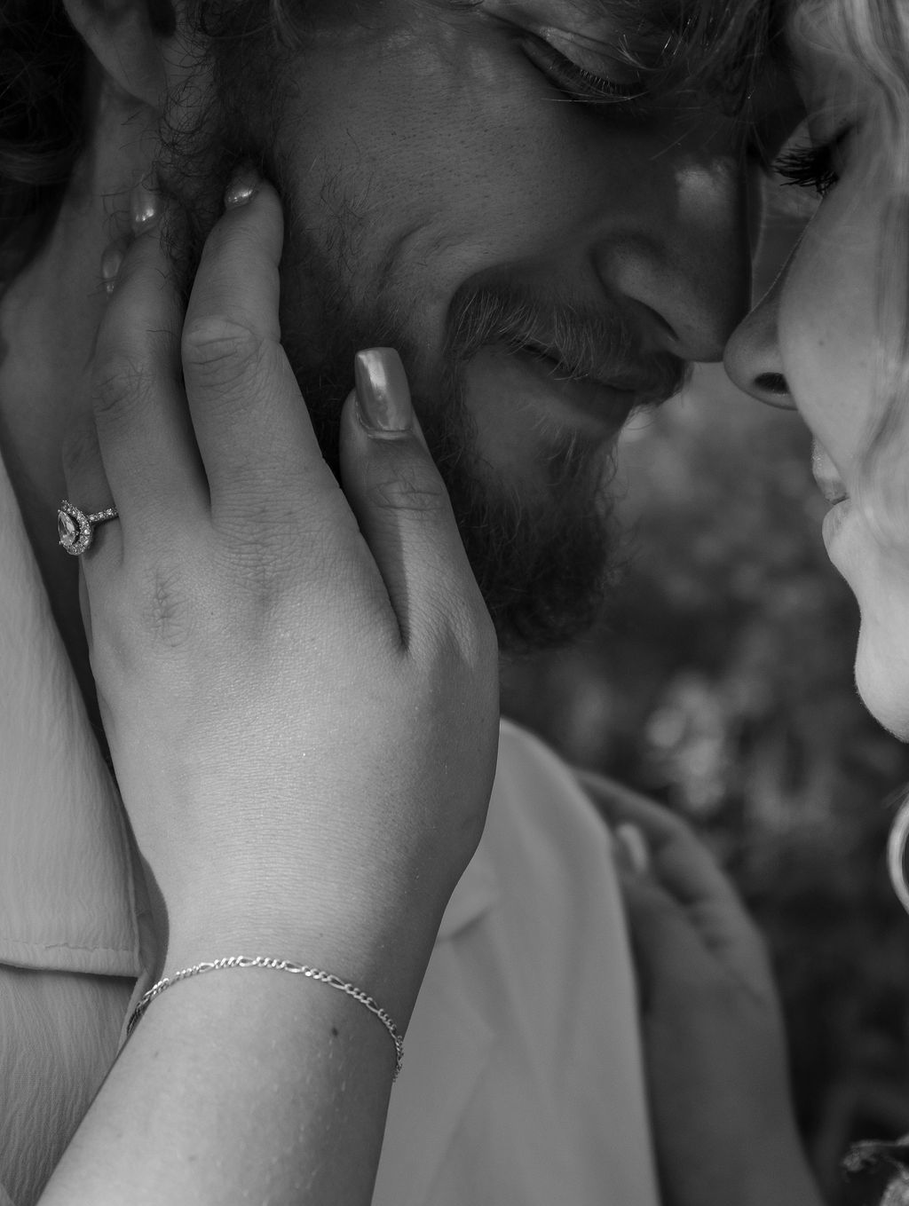 A close-up black and white photo showing hands caressing a face during an intimate moment.