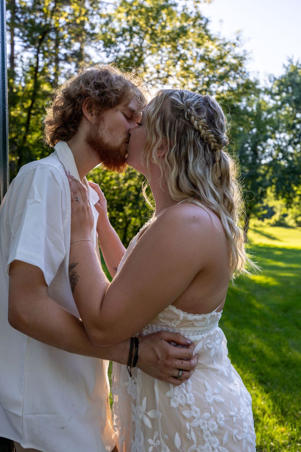 Sun-drenched garden scene with couple in romantic embrace.