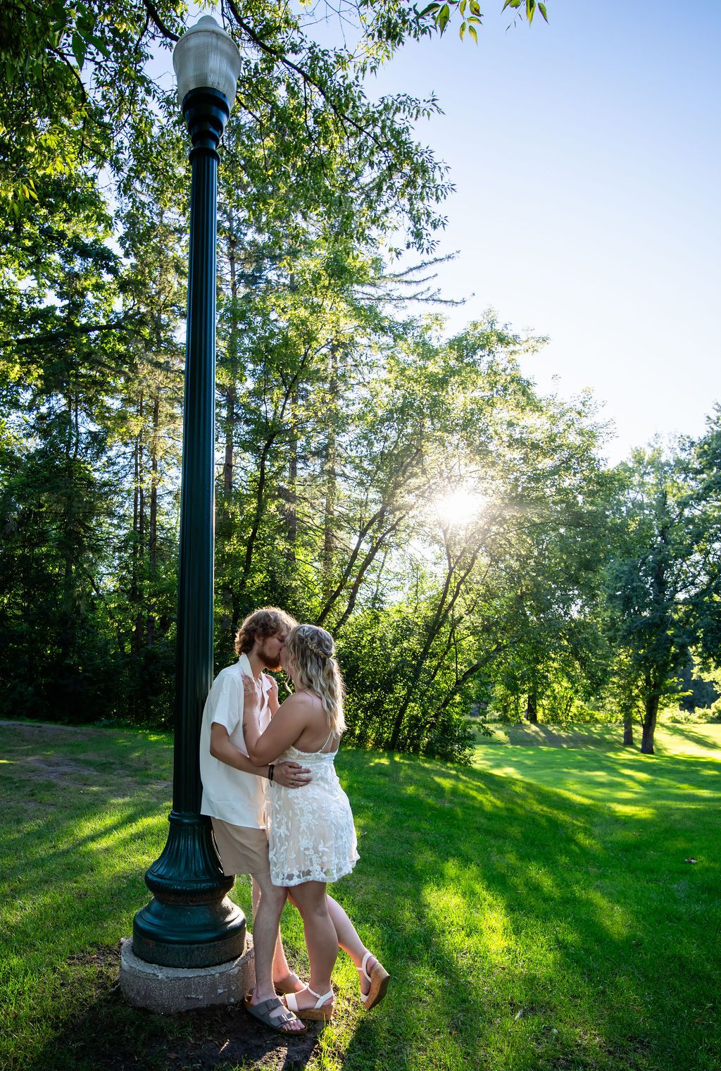 Summer garden romance captured near vintage lamppost with natural sunlight.