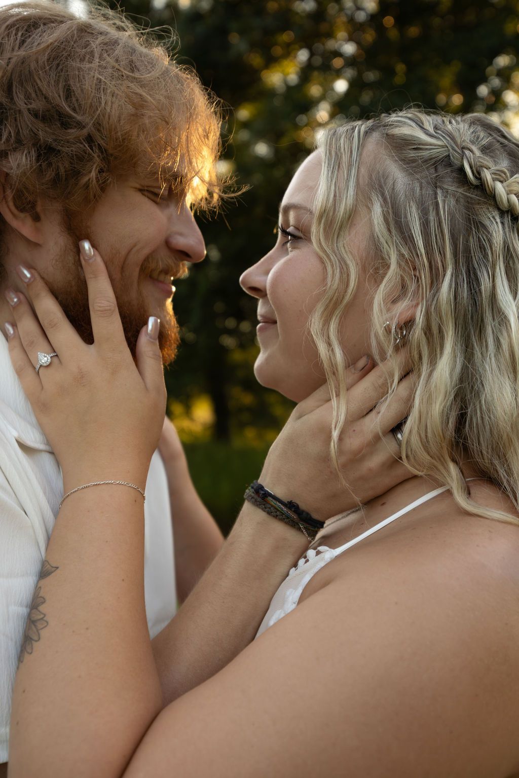 Close-up shot of a tender embrace between a couple in natural lighting.