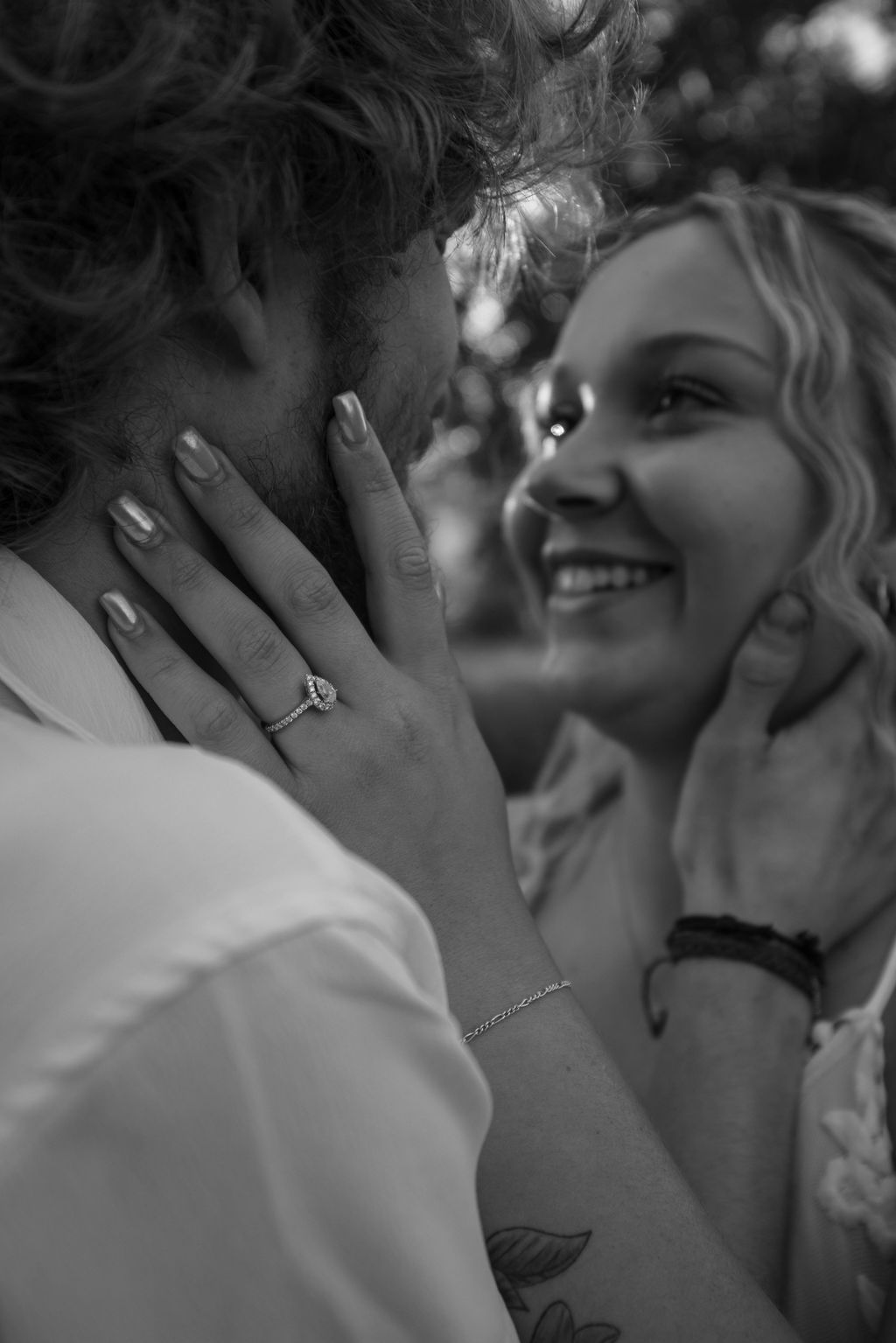 Black and white photograph capturing an intimate moment between a couple.