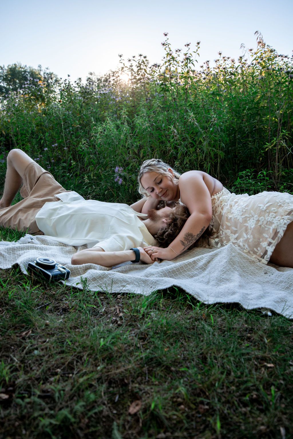 A romantic couple sharing a peaceful moment together in a summer meadow at sunset.