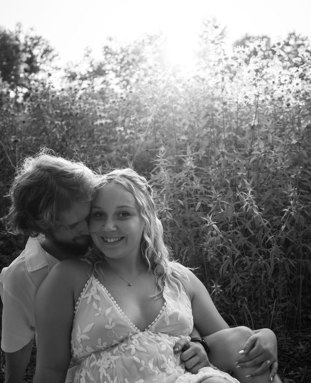 Intimate black and white portrait of couple sharing tender moment outdoors.
