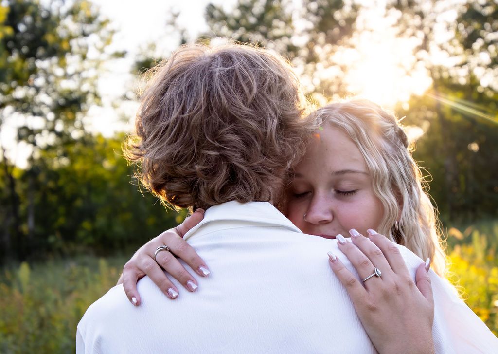 A tender moment captured during sunset in a natural meadow setting with warm light.