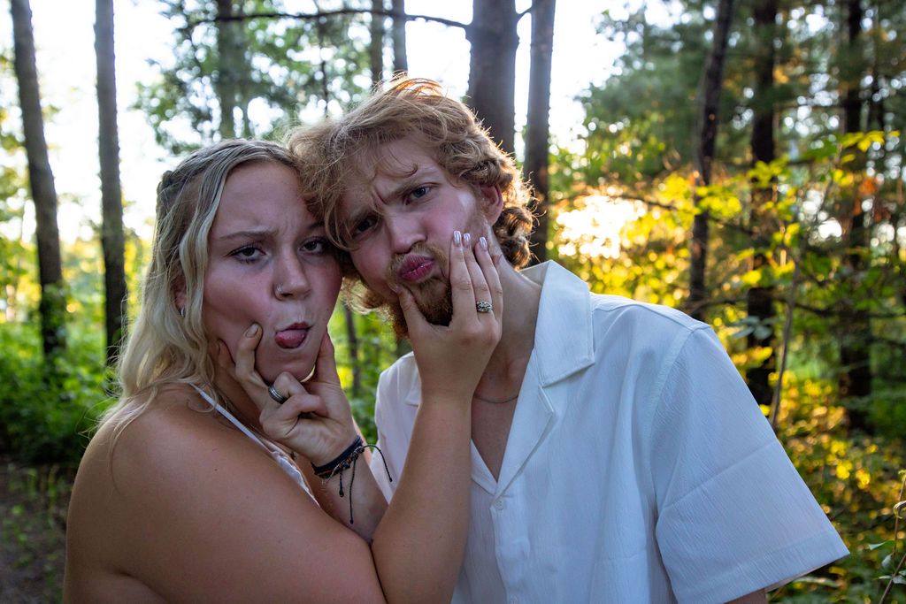Couple sharing a lighthearted moment and making silly expressions during their outdoor photo session.