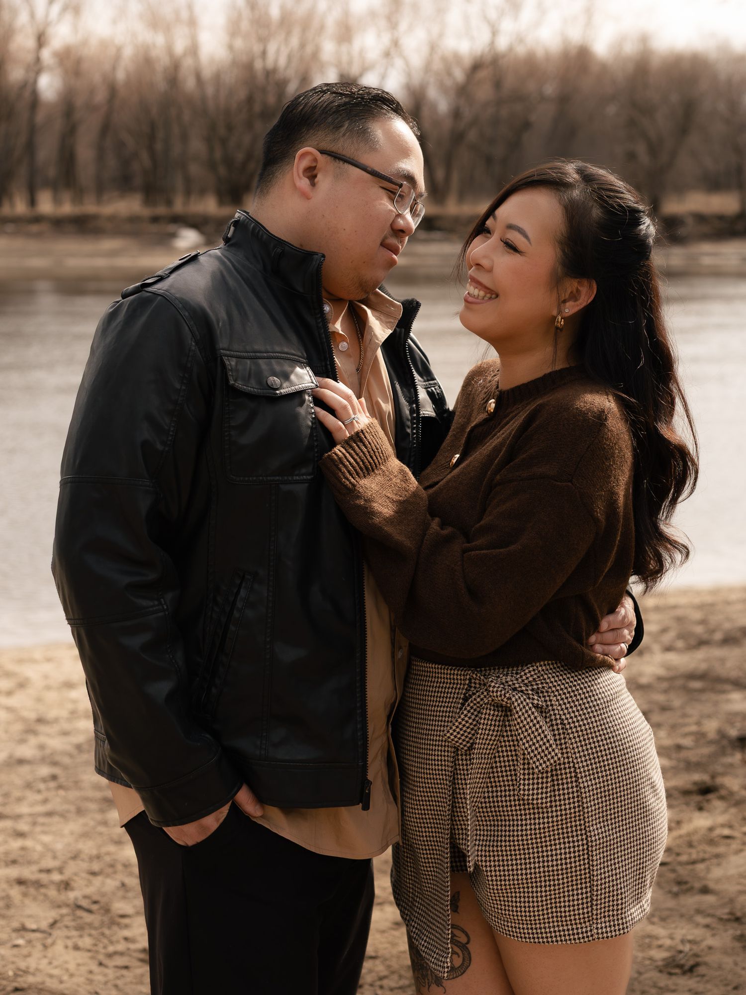 A couple shares tender moments in a series of romantic sepia-toned photos by a lake during autumn.