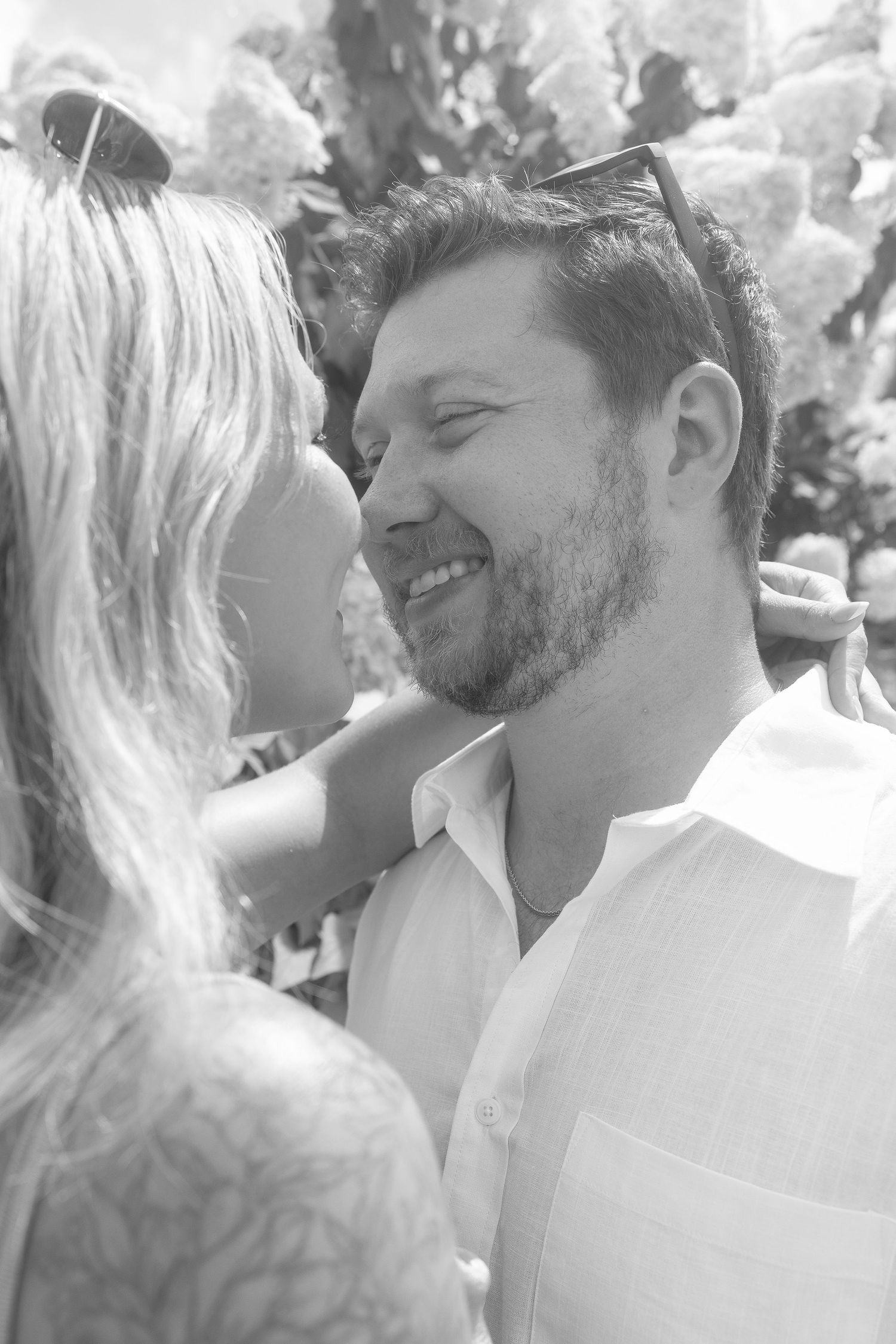 A series of intimate black and white photos showing a couple sharing tender moments outdoors.