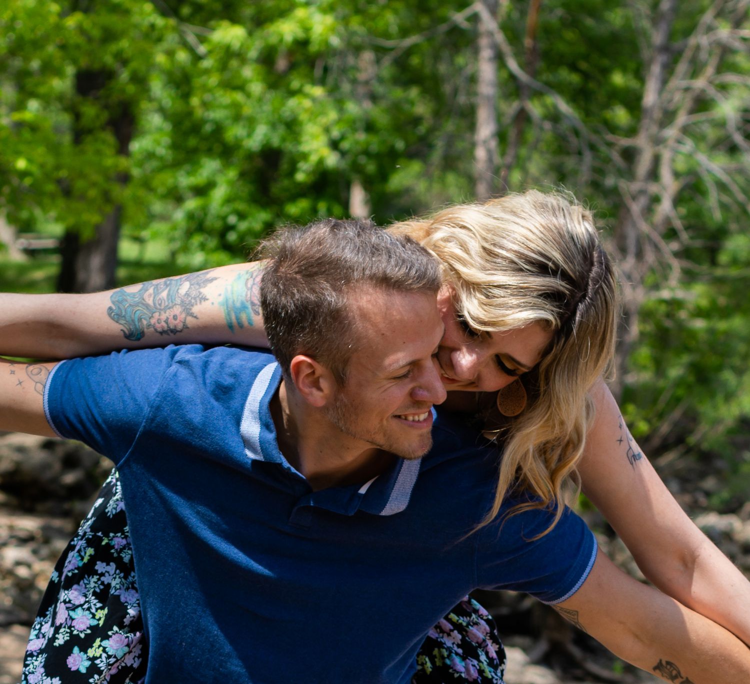 Couple sharing a playful piggyback ride moment in a sunny outdoor setting.