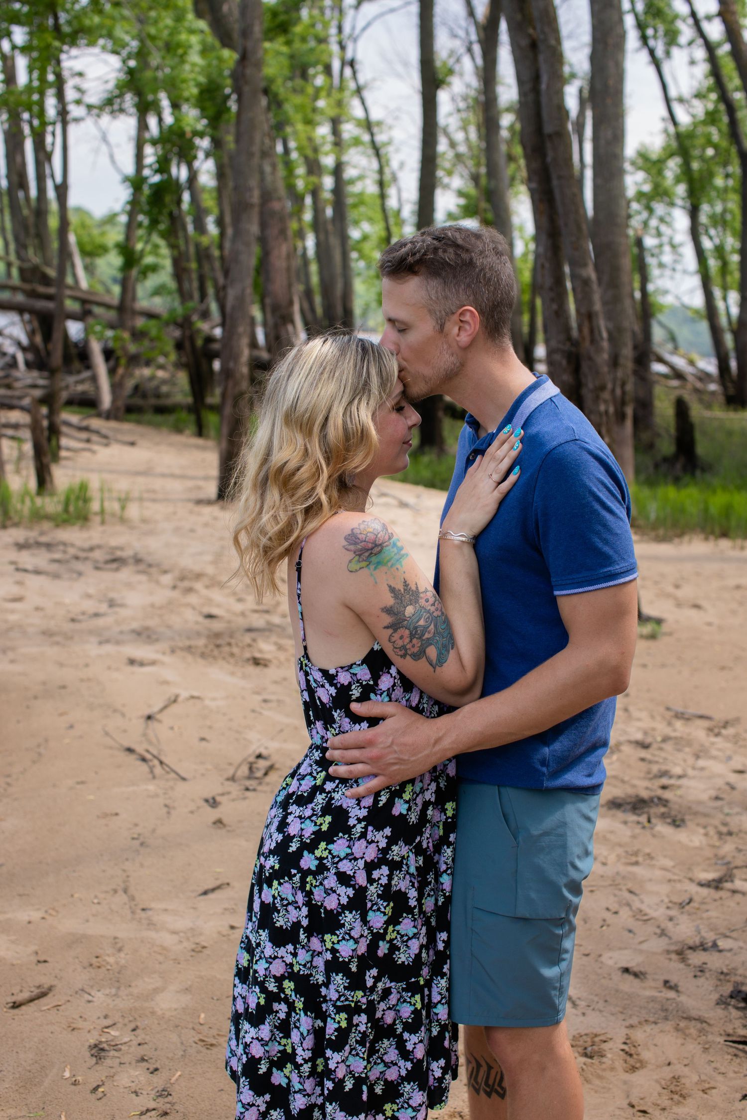 Couple sharing romantic moment on wooded beach path.