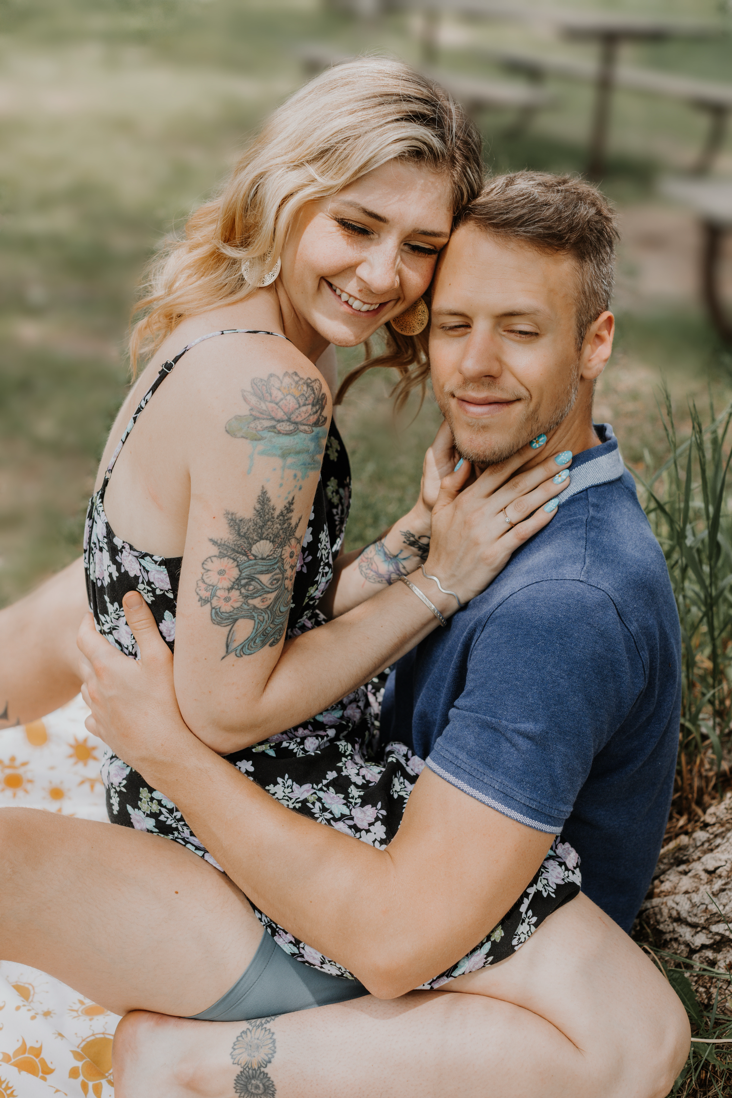 Intimate couple portrait showing affection outdoors with visible tattoos.