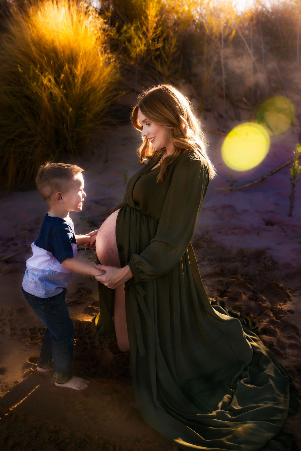 Backlit silhouettes of a mother and child share a tender moment in golden sunlight among fallen autumn leaves.