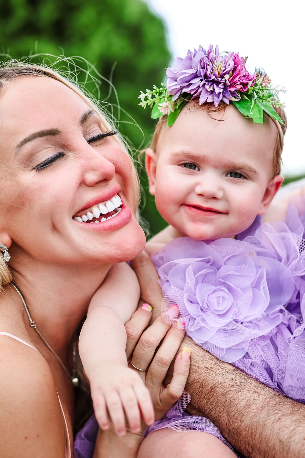 A candid image of a mother laughing while holding her baby daughter.