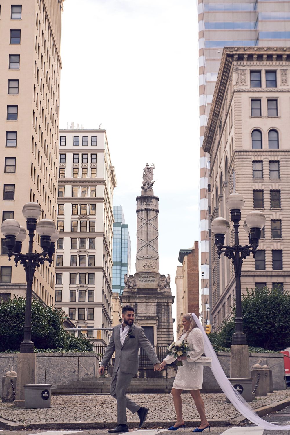 A romantic rooftop proposal scene with city buildings and elegant architecture in the background.