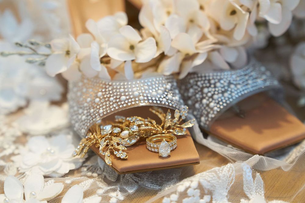 A collection of delicate bridal accessories including rhinestone jewelry, hairpieces and floral embellishments laid out on a table.