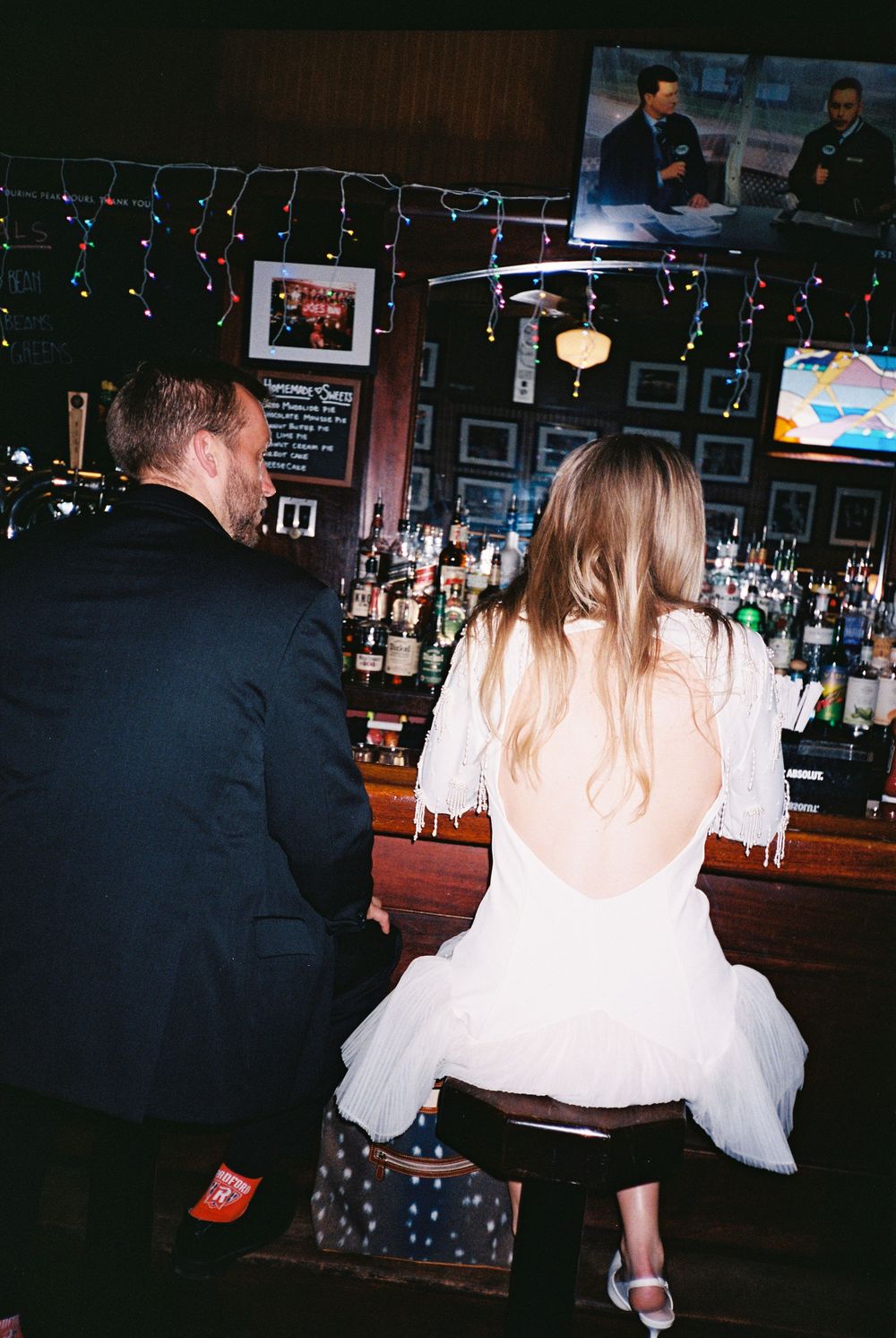 A series of candid bar photos showing patrons sitting at a dimly lit counter with festive holiday lights in the background.