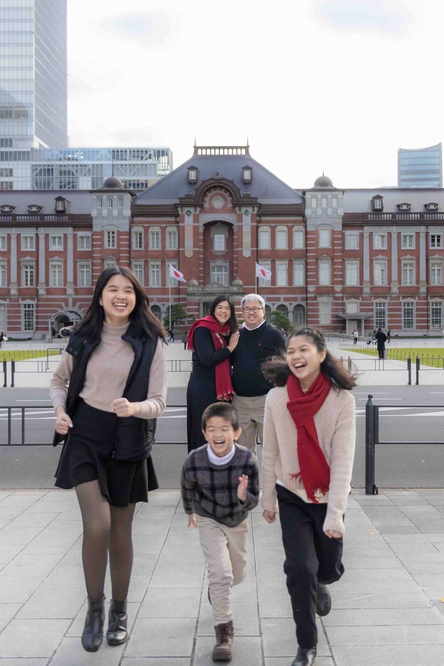 Group portrait of family members in front of historic Tokyo Station building.