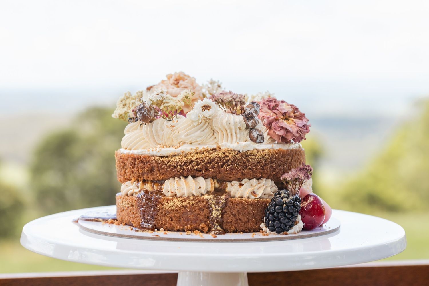 Rustic chocolate cake slices with berries served on white plates.