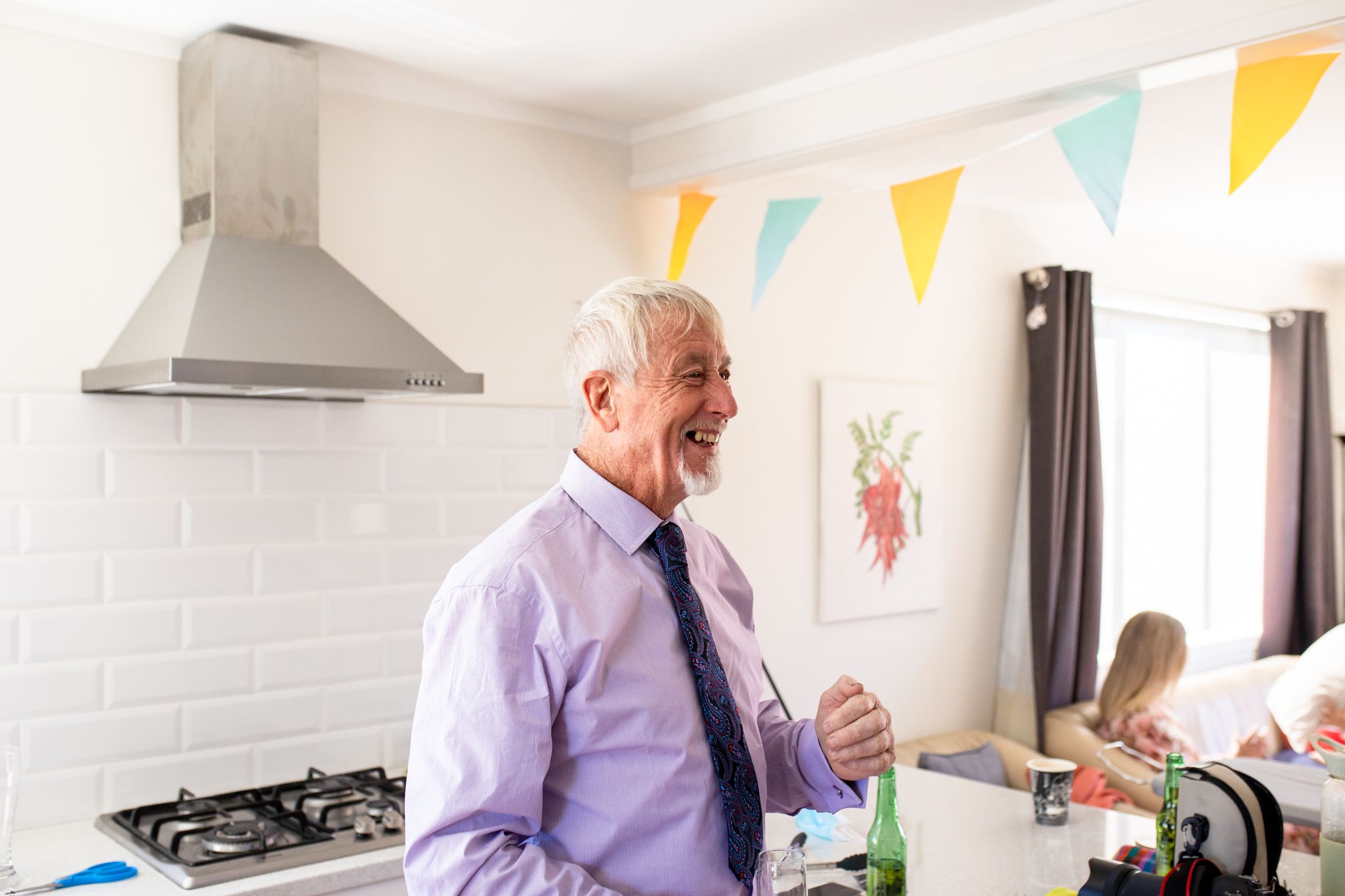 Joyful guest enjoying wedding celebration in modern kitchen with colorful bunting.