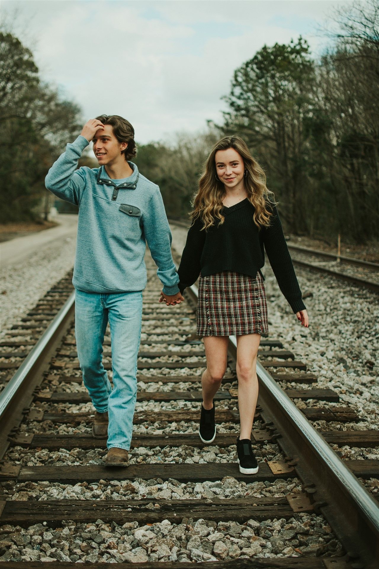 Playful elopement photos on railroad tracks, Helena Alabama elopement photos, Couple walking hand in hand outdoors.