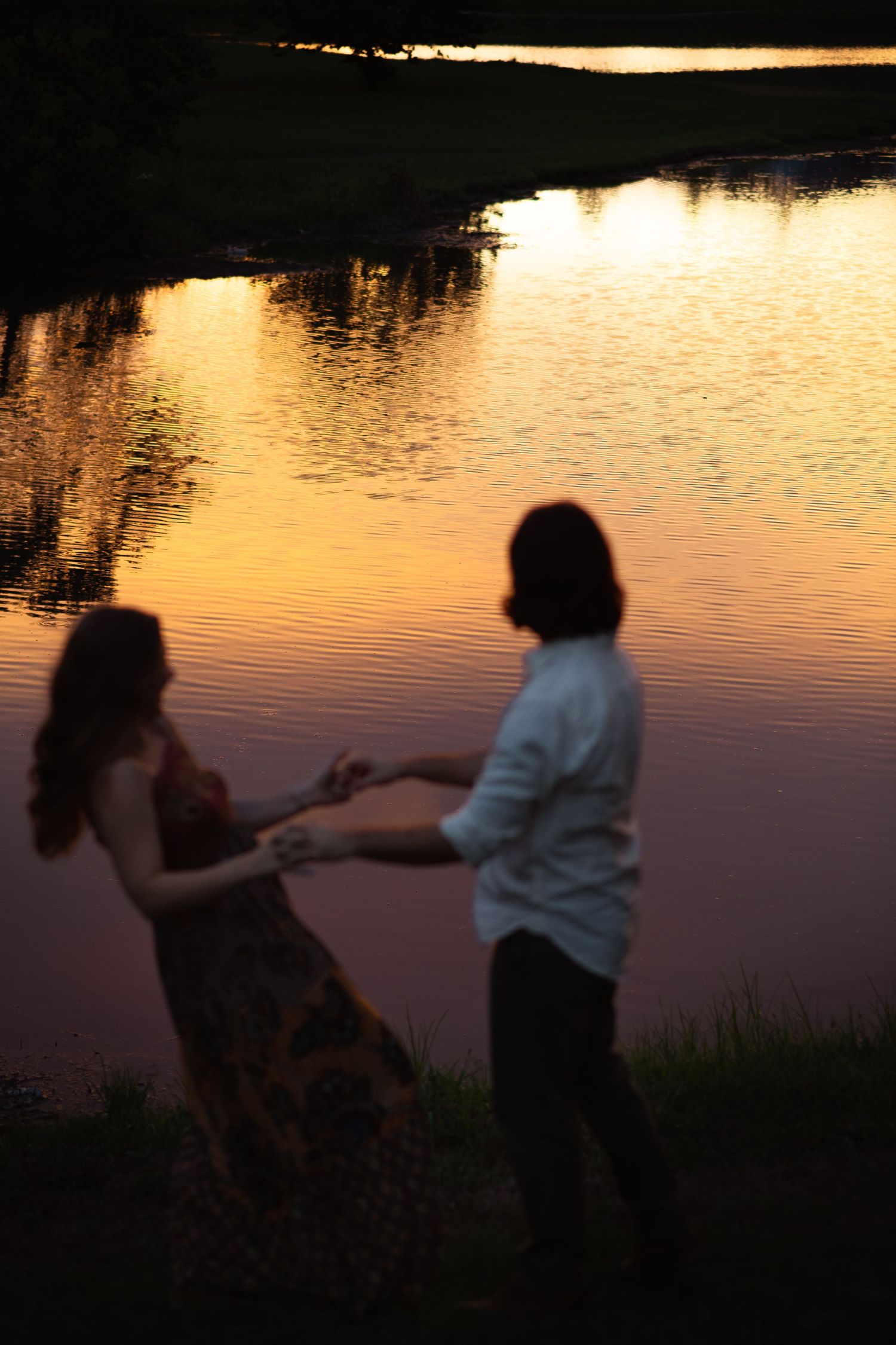 Sunset photography for couples in Hoover Alabama. Dancing couple in front of water sunset.