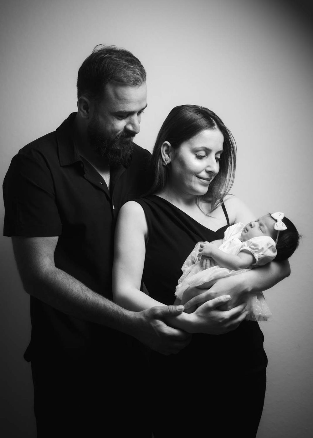 ein Schwarz und weiß Foto von Eltern und das Baby in einem Fotoshooting bei dem Eltern zuhause in Köln Stadt.