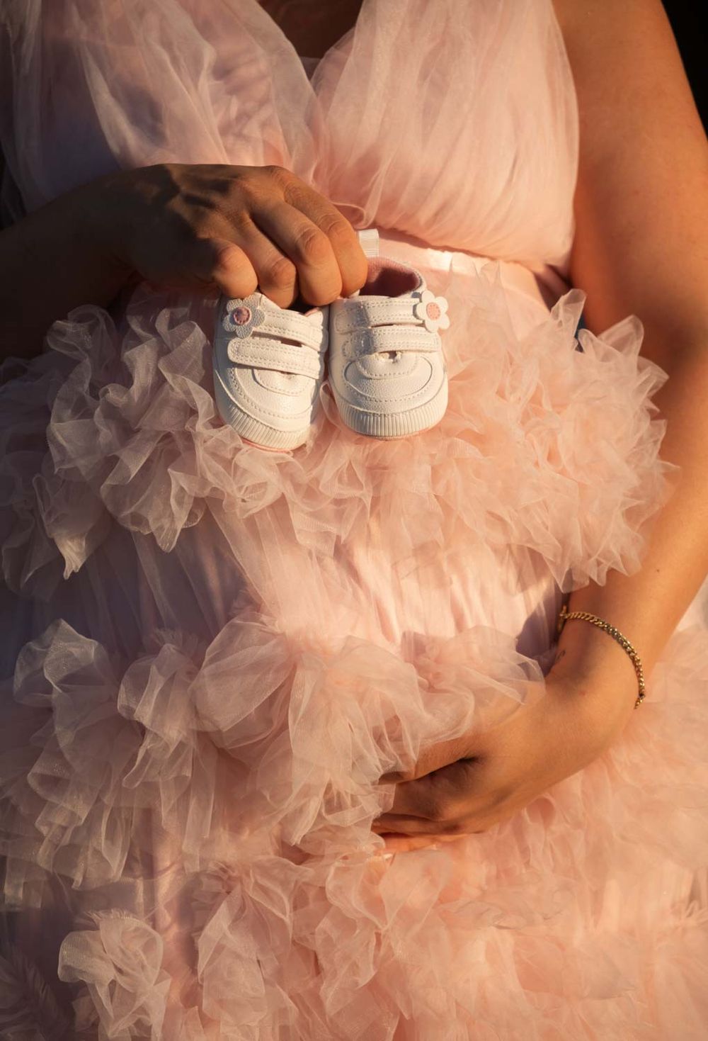 ein foto von einer schwangeren Dame in einem Babybauch-Fotoshooting draußen in natürlichem Licht.