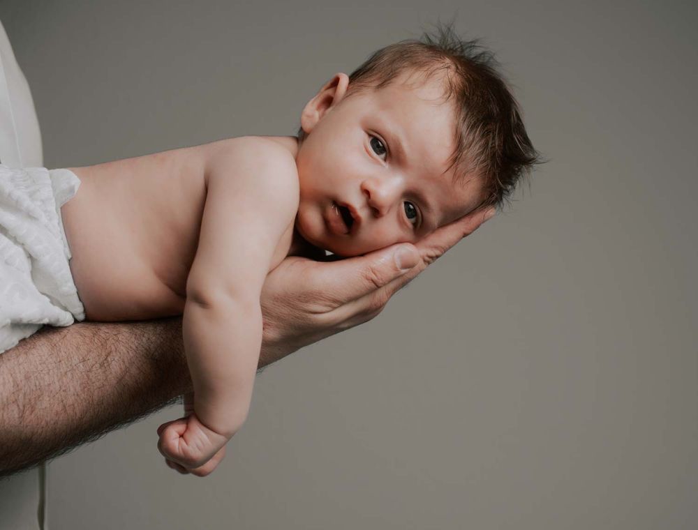 ein 4 Wochen alt baby in einem Baby Fotoshooting bei den Eltern zuhause