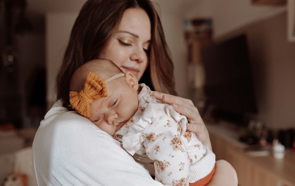 ein Foto von Mutter und dem neuen Baby in einem neugeborenen-Fotoshooting bei den Eltern zuhause, in NRW