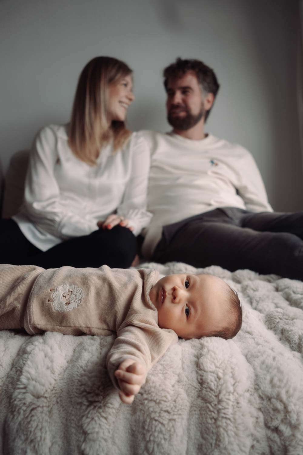 ein 4 Wochen alt baby  mit sein Eltern in einem Baby Fotoshooting bei den Eltern zuhause mit natürlichem Licht zuhause.