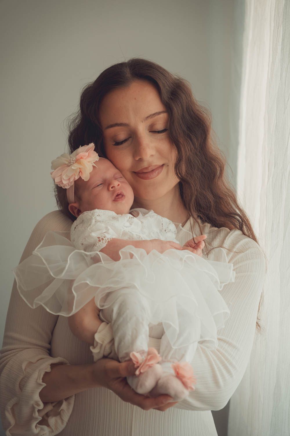 eine Mutter mit ihrem Baby in einem Baby Fotoshooting bei dem Eltern zuhause. ein fotoshooting mit natürlichem Licht.