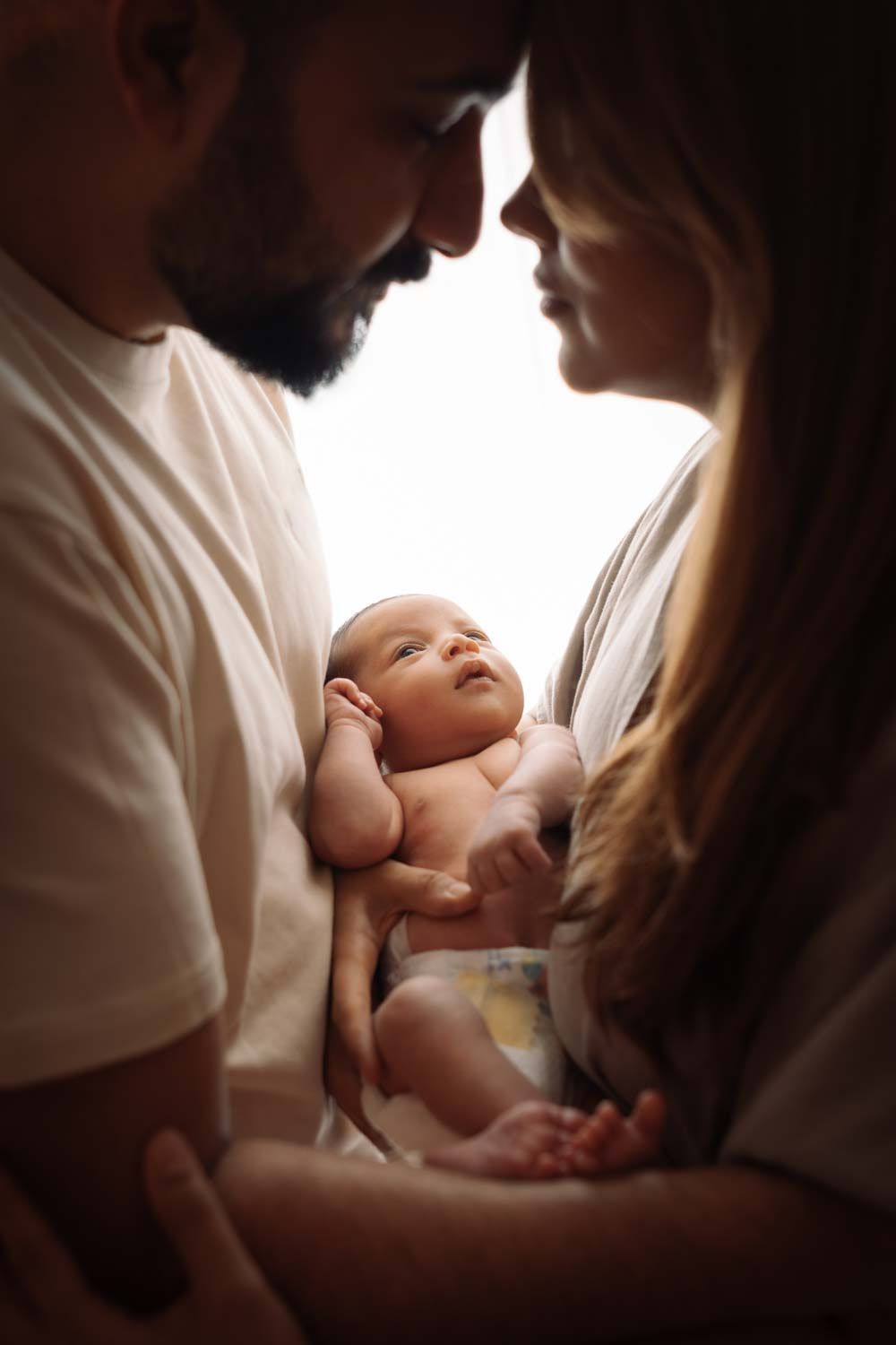 ein Foto von Eltern und das Baby in einem Fotoshooting bei dem Eltern zuhause in Köln Stadt.