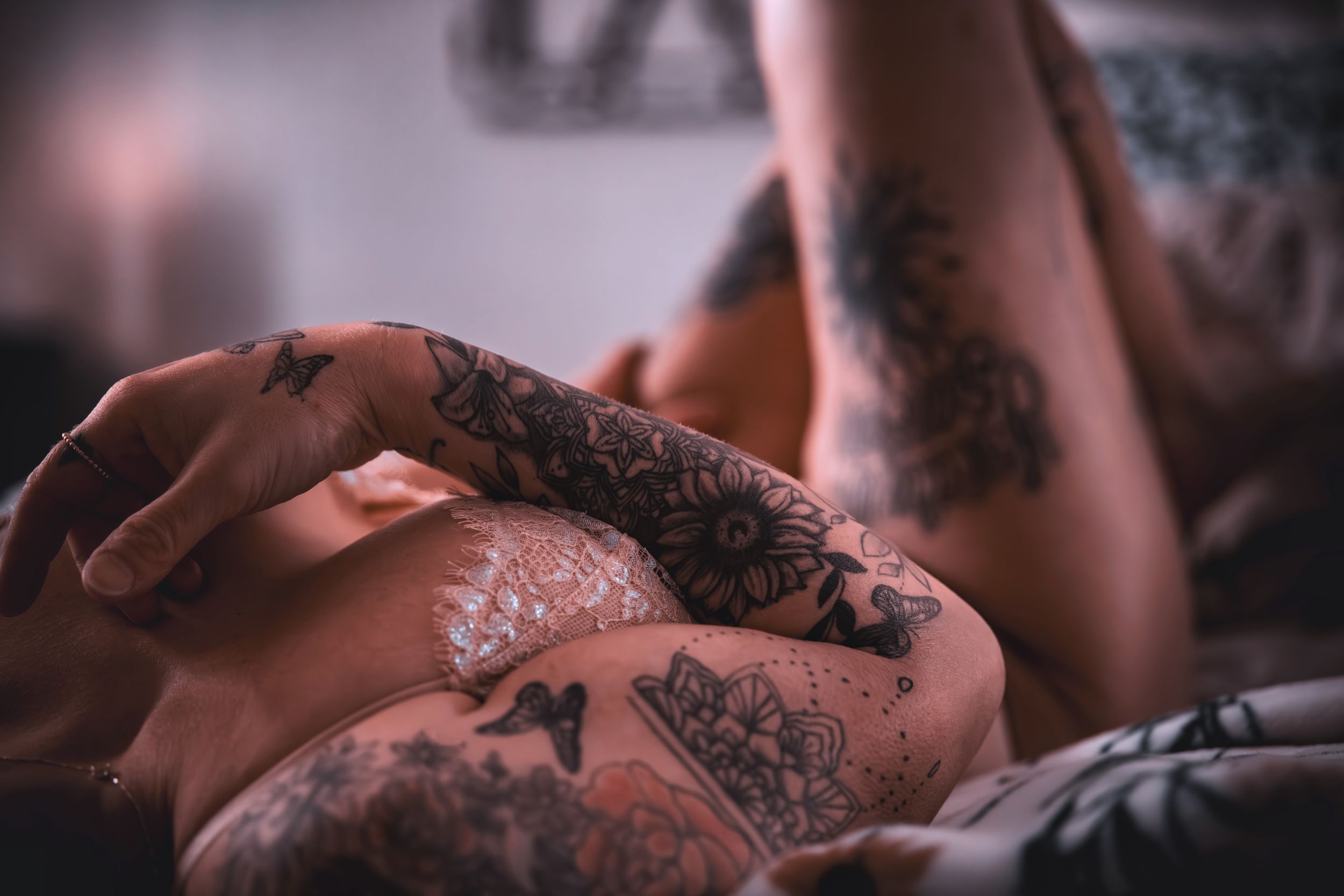 Close-up artistic photography highlighting tattoo details in moody lighting.