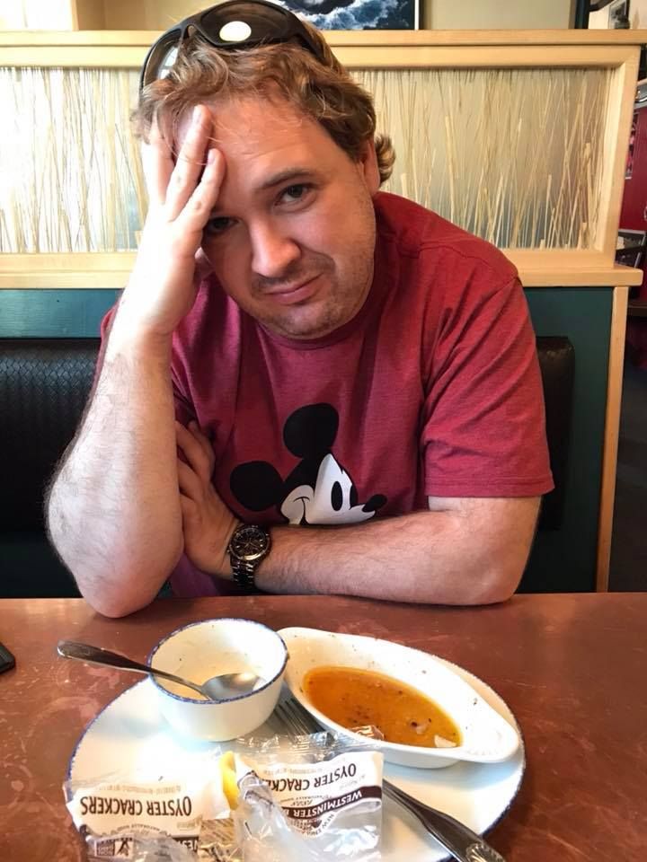 Person at restaurant table with partially eaten meal.