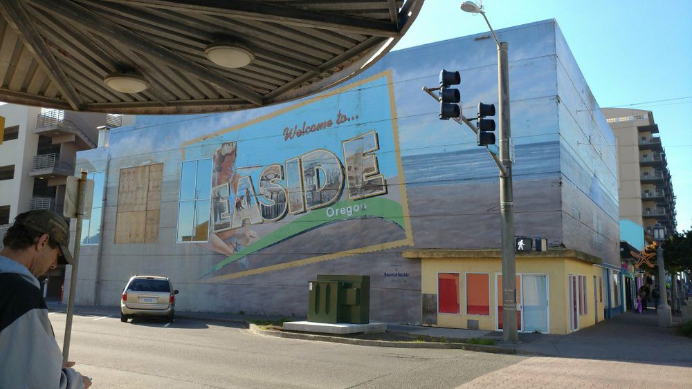 Exterior view of Inside restaurant with painted mural signage on side of urban building.
