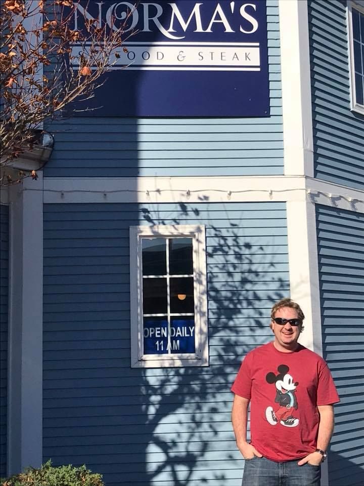 Exterior of Norma's Seafood & Steak restaurant with person standing outside blue building.