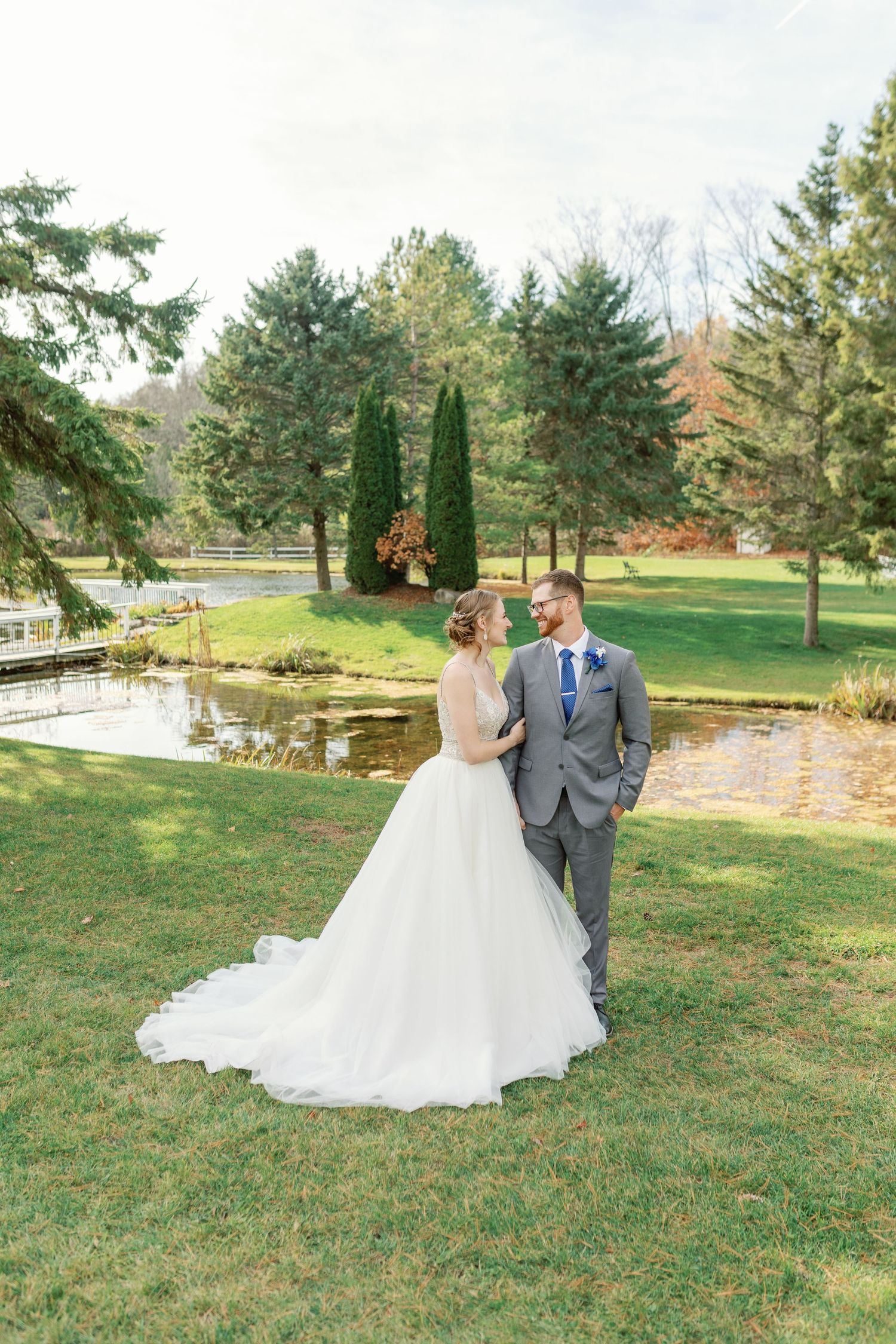 A bride and groom smiling at each other at Trillium Trails in Oshawa. Taken by Wedding Photographer, Katie Crane.
