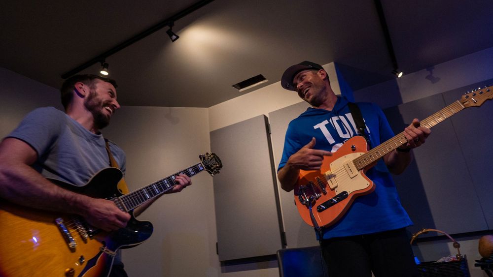 Two friends playing guitar