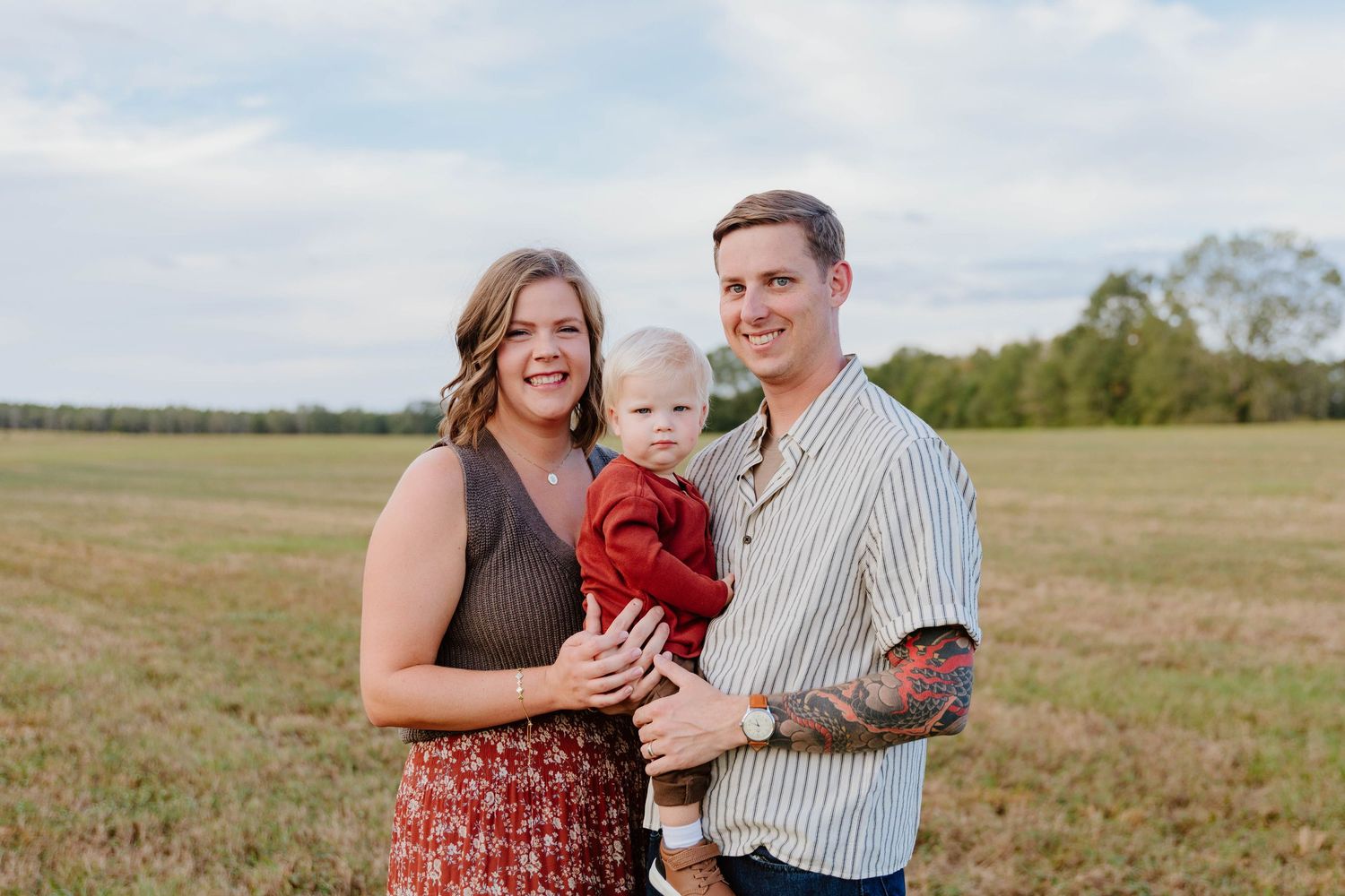 Family portrait session in open field during golden hour with rustic style clothing.
