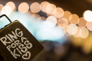 Ring for Kiss in front of bokeh lights at wedding in lake genava wisconsin