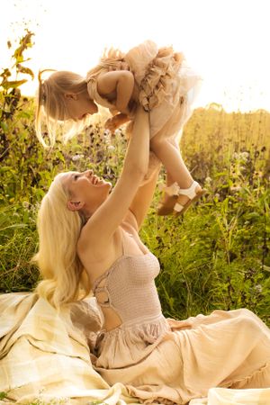 Mother lifts daughter into the air playfully in milwaukee wisconsin family photo