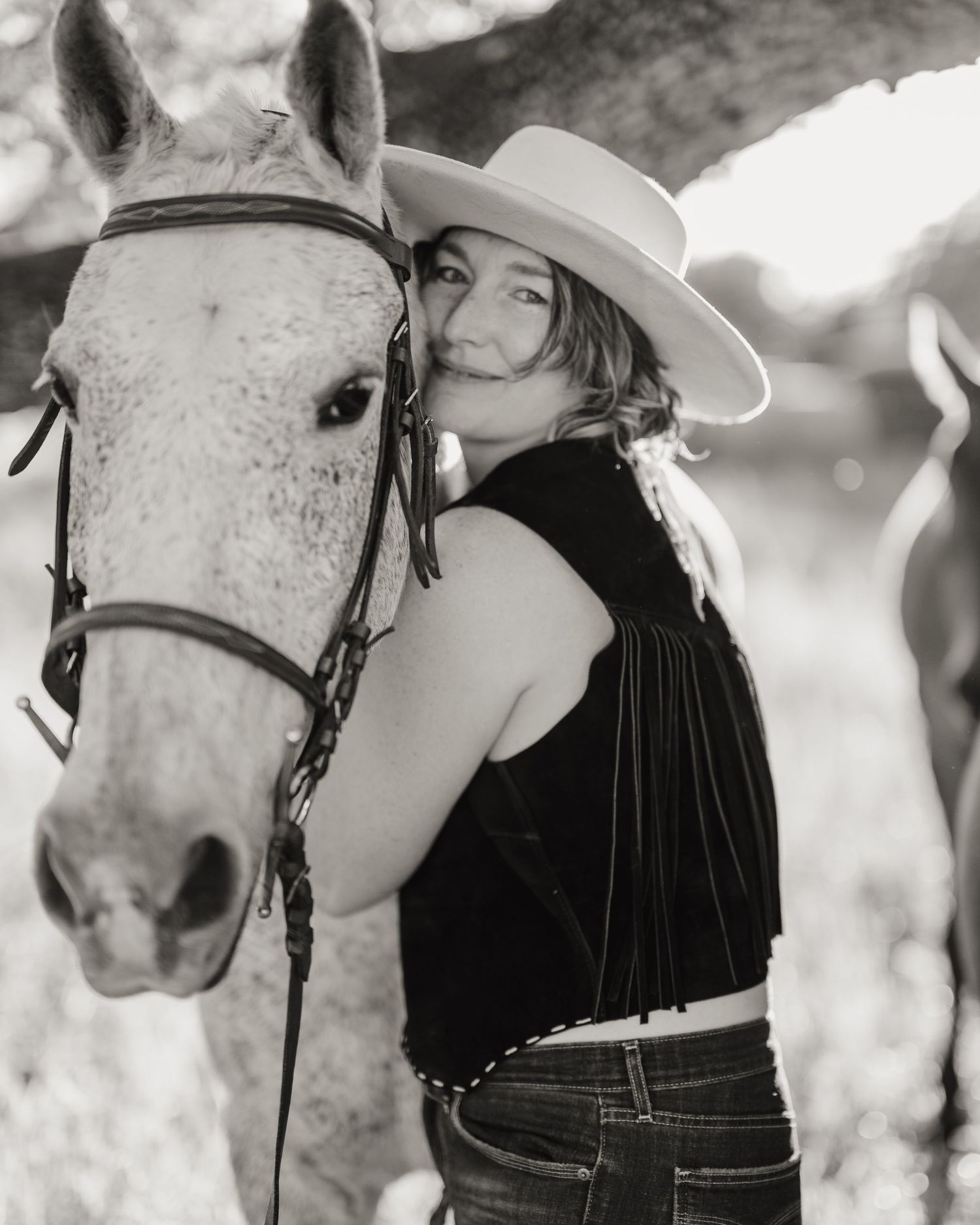 Black and white portrait with white horse showing close connection between horse and rider.