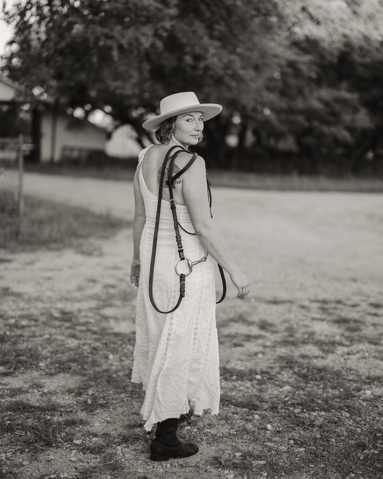 Black and white images of a person in a white dress walking through an open field.