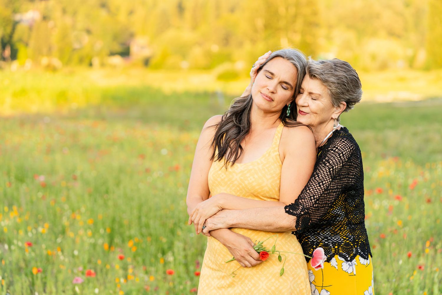 Grandmother hugs daughter in a field of wildflowers in Woodinville.