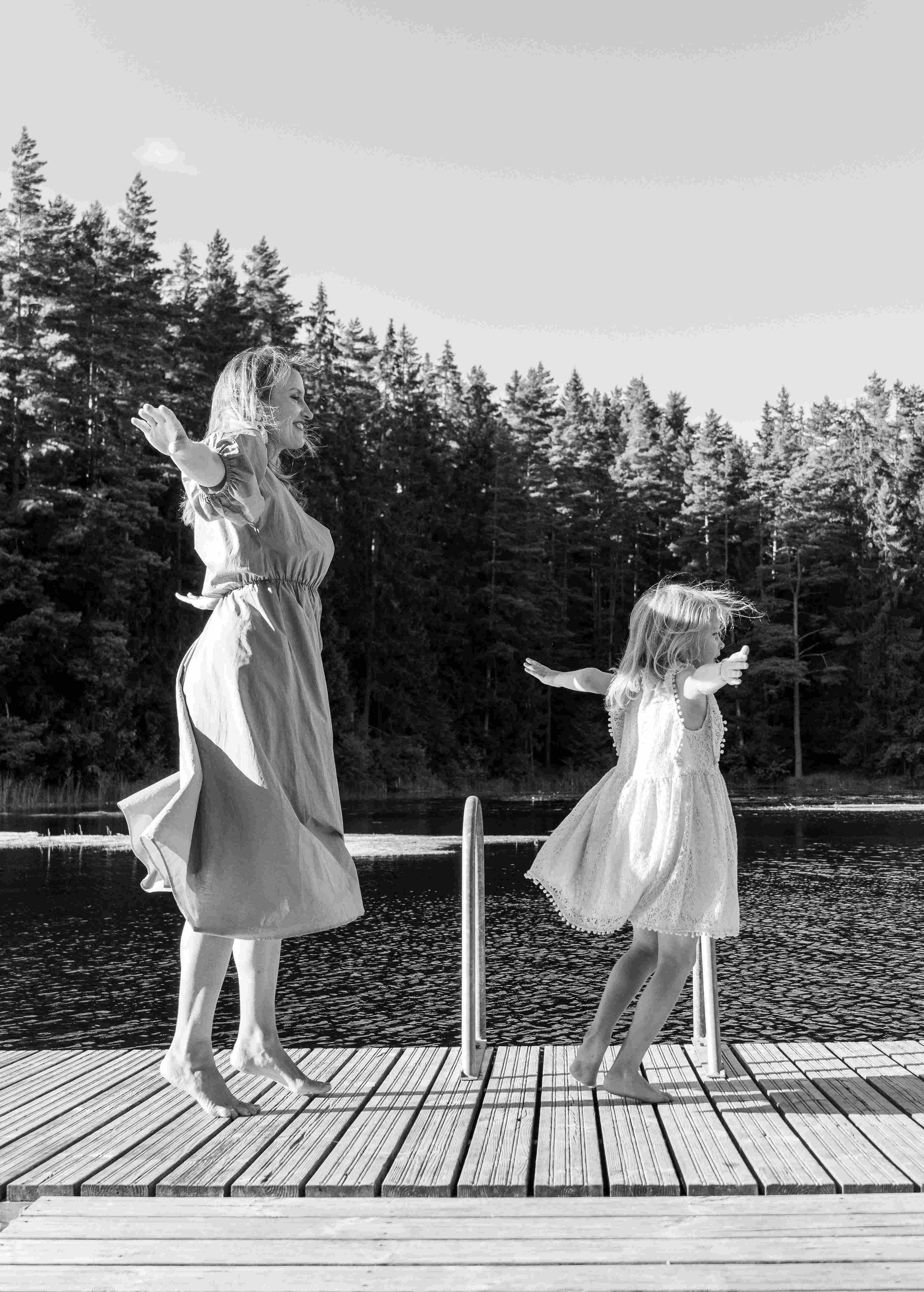 A mother and daughter are dancing together.