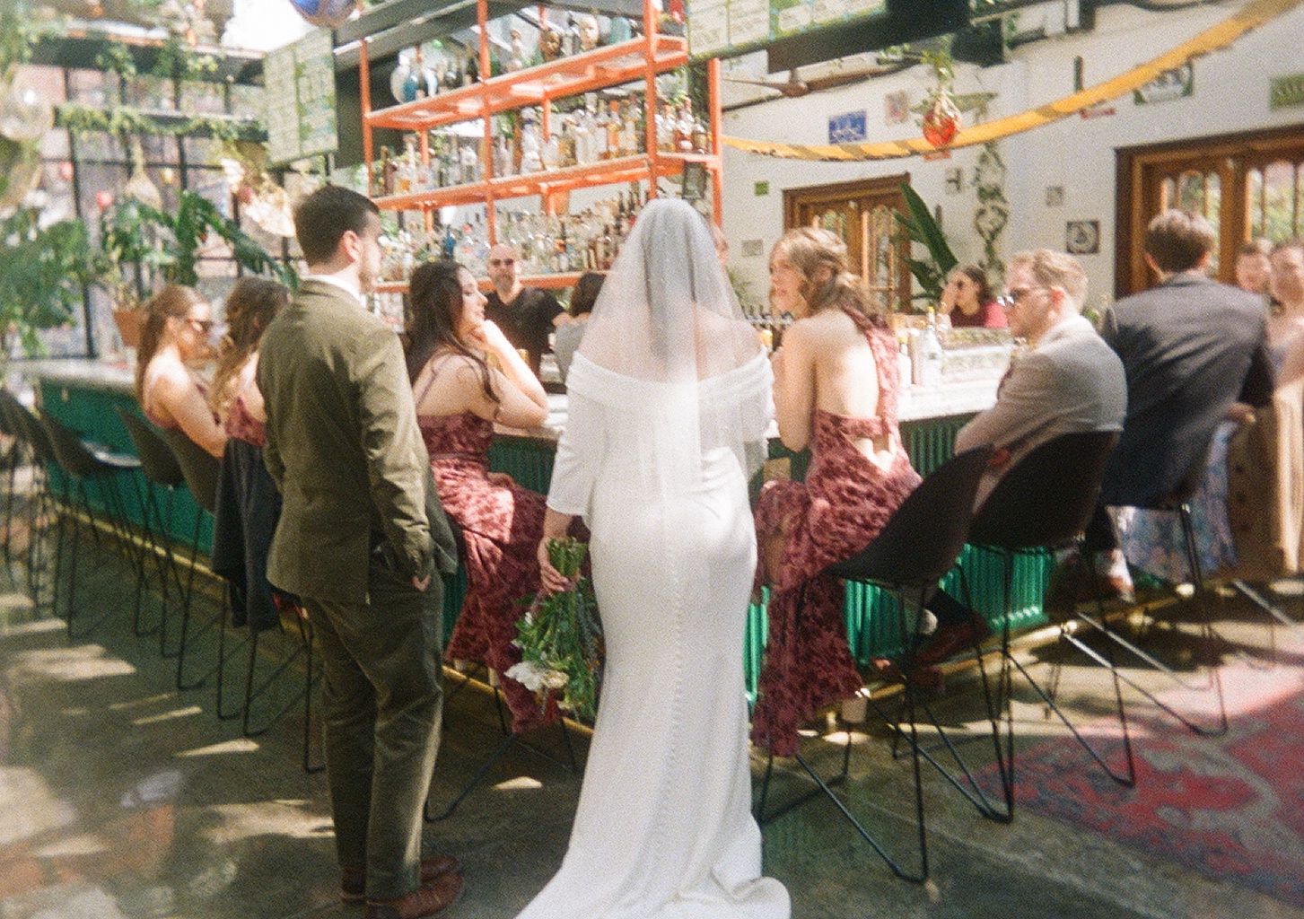 A wedding reception scene on an outdoor patio with guests seated at decorated tables.
